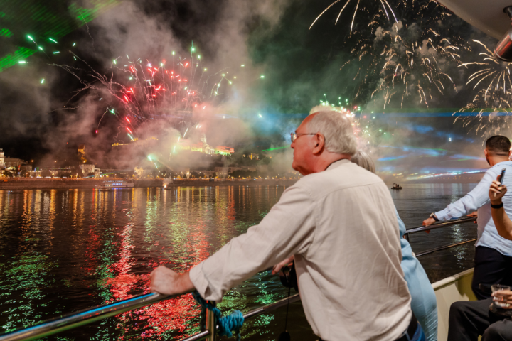 People watch fireworks overthe river.