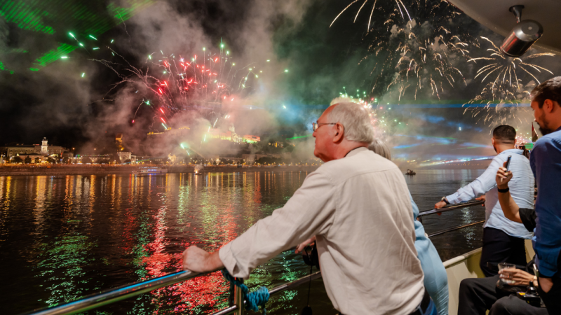 People watch fireworks overthe river.